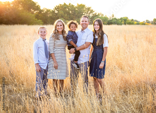 Fotografía An elegant and beautiful young family portrait outdoors in a grassy field