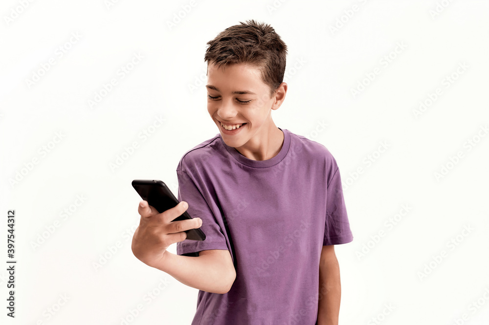 Teenaged disabled boy with cerebral palsy looking happy while holding and using smartphone, posing isolated over white background Teenaged disabled boy with cerebral palsy looking happy while holding and using smartphone, posing isolated over white background