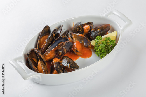 Blue mussels in tomatoes, white background