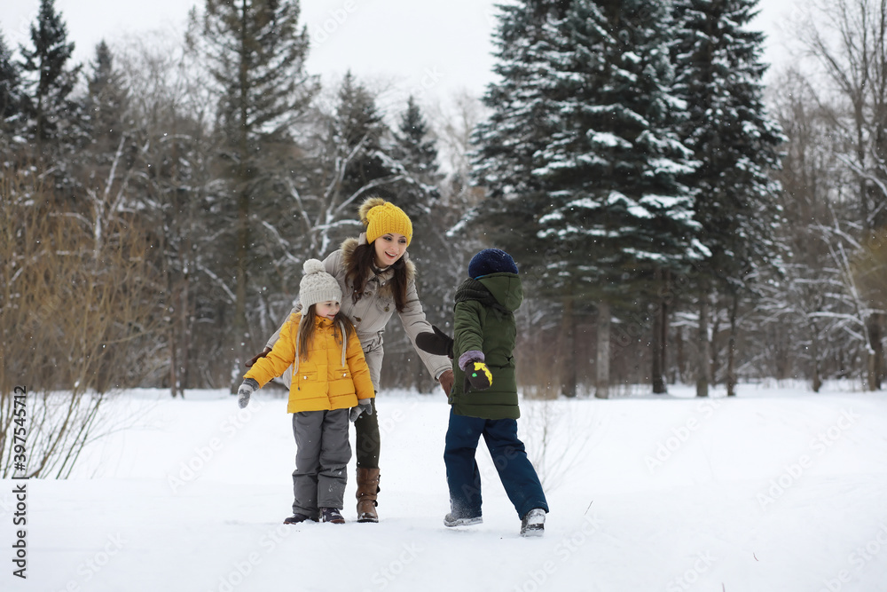 Happy family playing and laughing in winter outdoors in the snow. City park winter day.