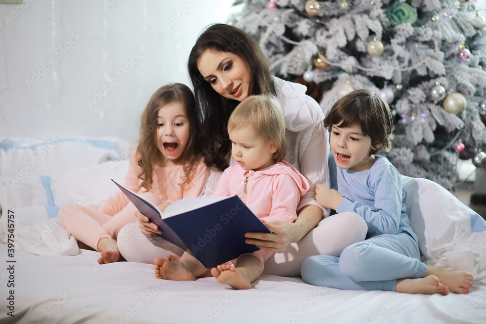 A family with children having fun on the bed under the covers during the Christmas holidays. A family with children having fun on the bed under the covers during the Christmas holidays.