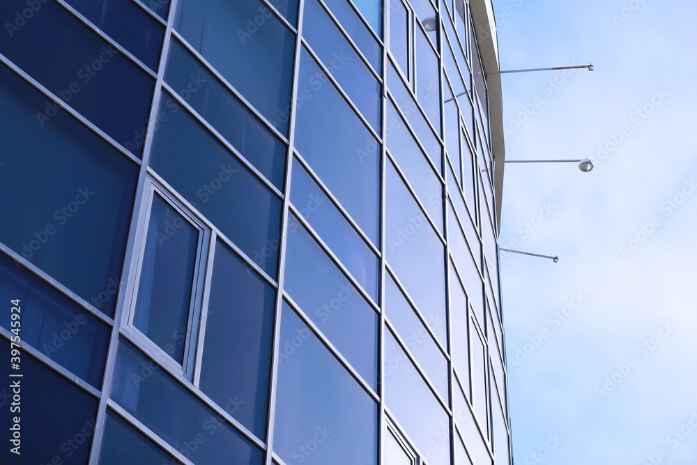 Architectural detail of the facade with multiple reflections of other buildings and the sun. Modern building. Architecture background Architectural detail of the facade with multiple reflections of other buildings and the sun. Modern building. Architecture background