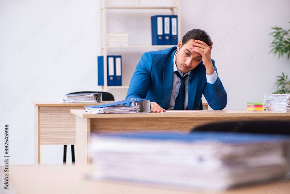 Young businessman employee unhappy with excessive work in the of Young businessman employee unhappy with excessive work in the of