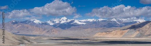 Spectacular panorama with snow-capped mountain range and pastel colors on the high-altitude Pamir Highway between Karakul and Kyzyl Art pass, Murghab district, Gorno-Badakhshan region, Tajikistan