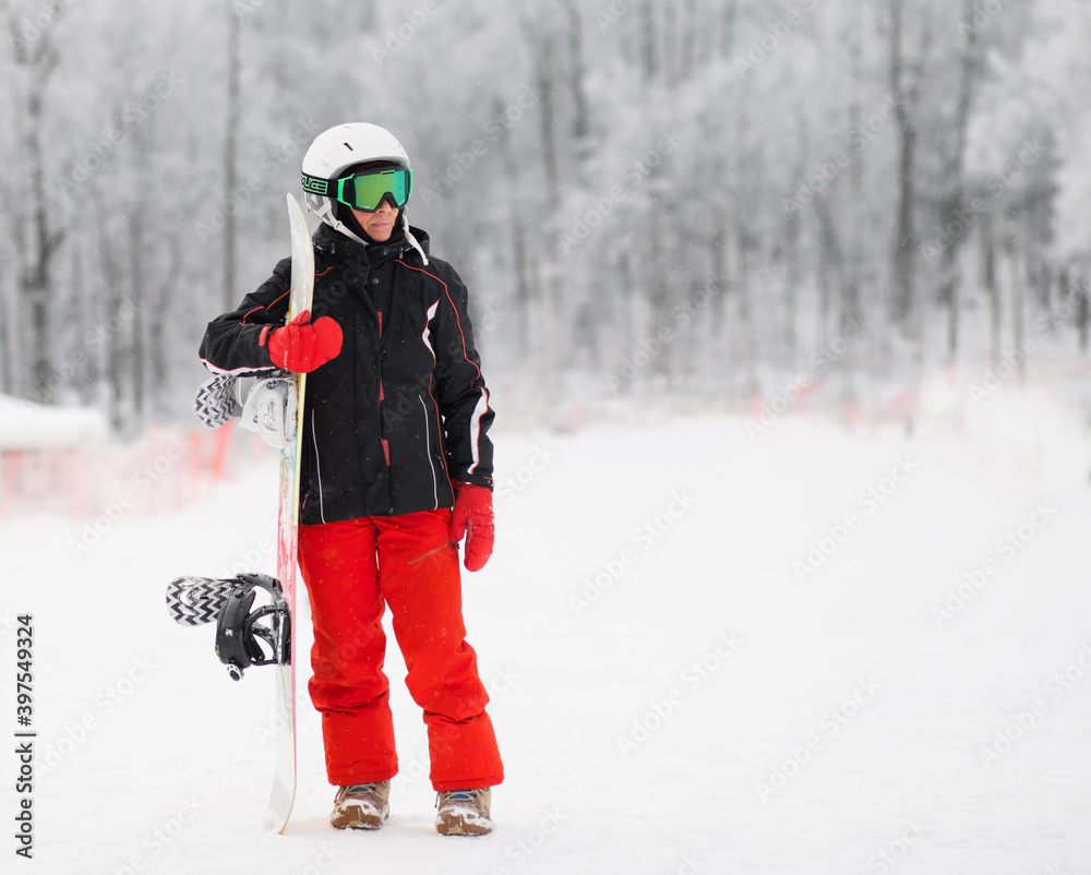 Senior woman with snowboard stand in winter mountain