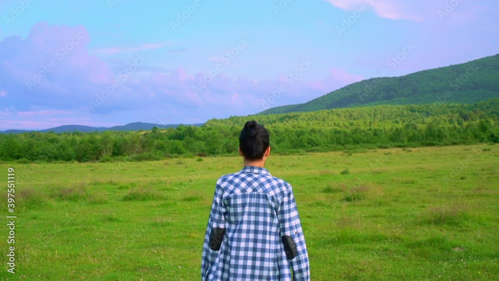back view woman walking on the meadow slow motion beautiful evening sky with purple sky mountains landscape back view woman walking on the meadow slow motion beautiful evening sky with purple sky mountains landscape