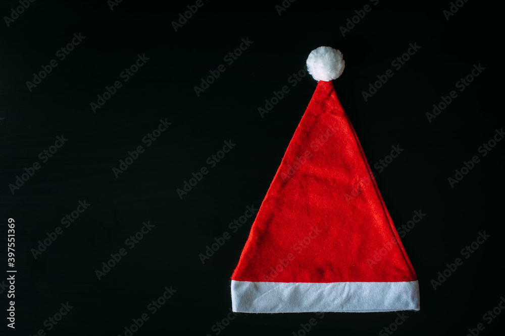 Red Santa Claus hat isolated on black background with copy space. Father Christmas cap, close up. New year concept. Red Santa Claus hat isolated on black background with copy space. Father Christmas cap, close up. New year concept.