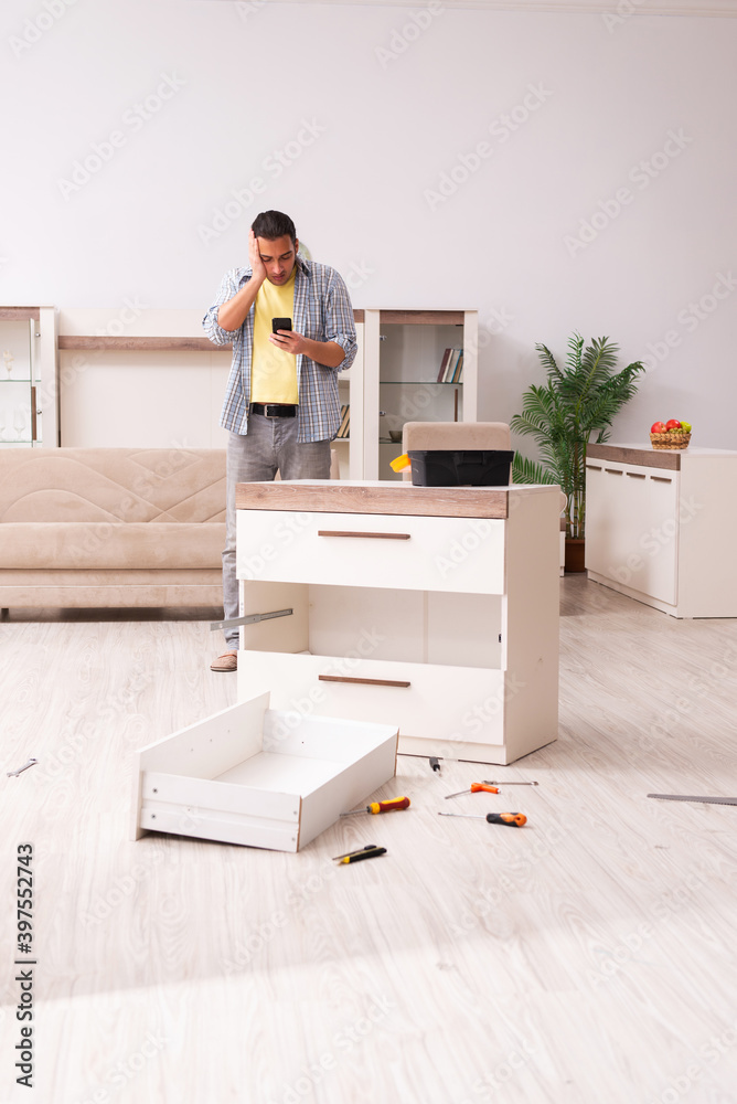 Young male carpenter repairing furniture at home Young male carpenter repairing furniture at home