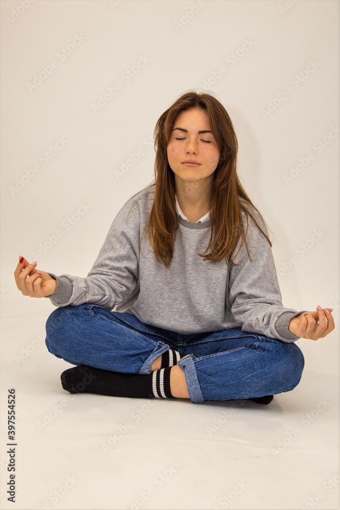 Fototapeta premium Beautiful blower sits on the floor of a student white background the joy of meditation calm happiness smile