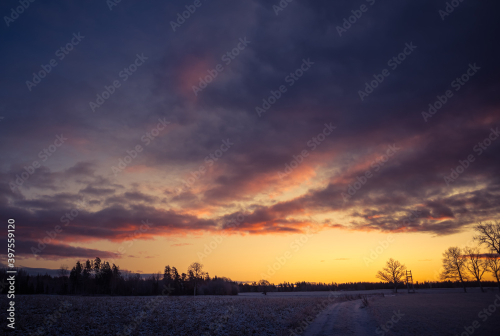 A beautiful, bright, colorful landscape of a winter sunrise. Bright sky and first snow. Winter scenery of a Northern Europe during the sunrise.