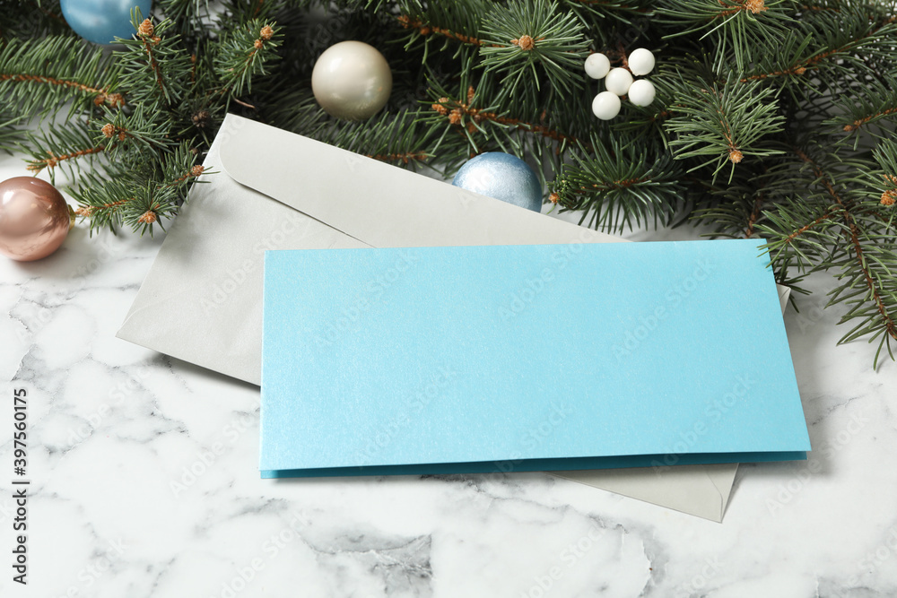 Blank greeting card, envelope and Christmas decor on white marble table. Space for text Blank greeting card, envelope and Christmas decor on white marble table. Space for text