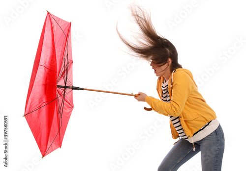 Woman with umbrella caught in gust of wind on white background