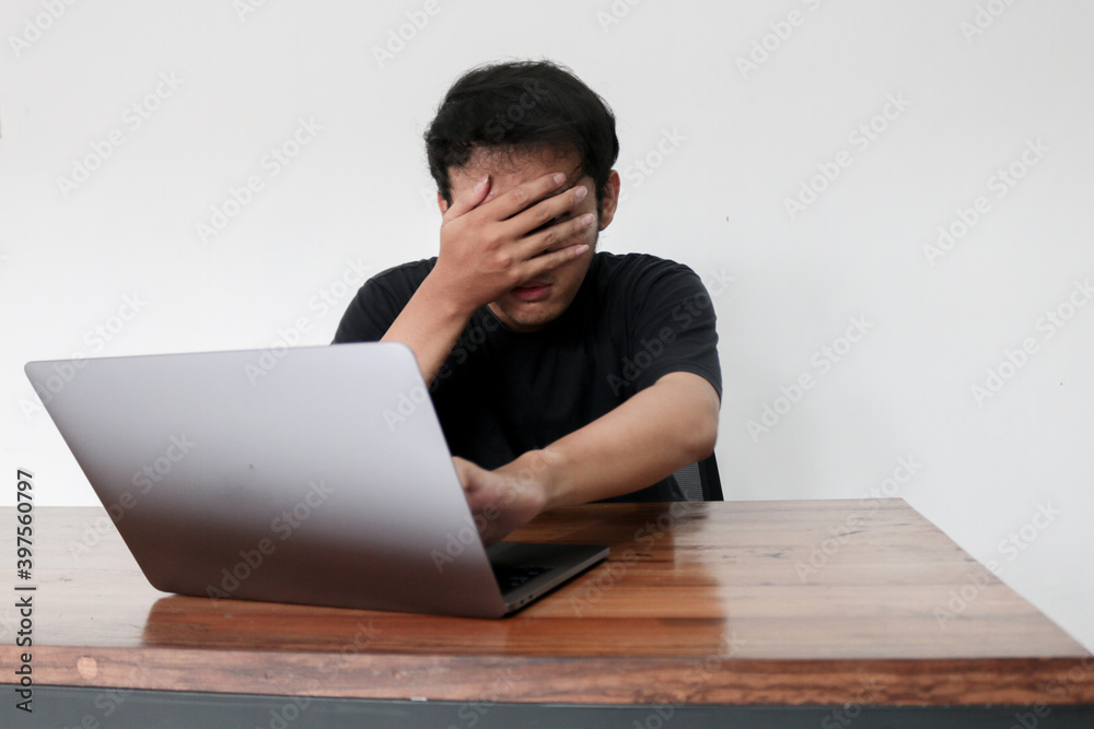 Stockfoto Young asian man hiding his face with hand because shocked and  embarrassed by some porn videos or another forbidden thing he saw on the  internet using a laptop | Adobe Stock