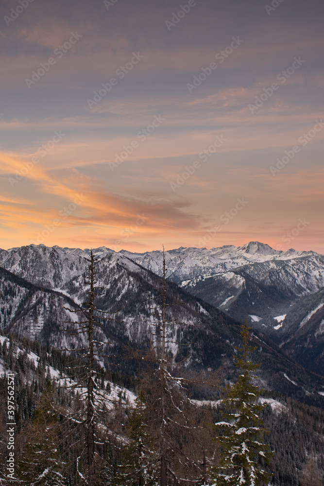Sonnenaufgang in den Alpen mit sanft gefärbten Wolken