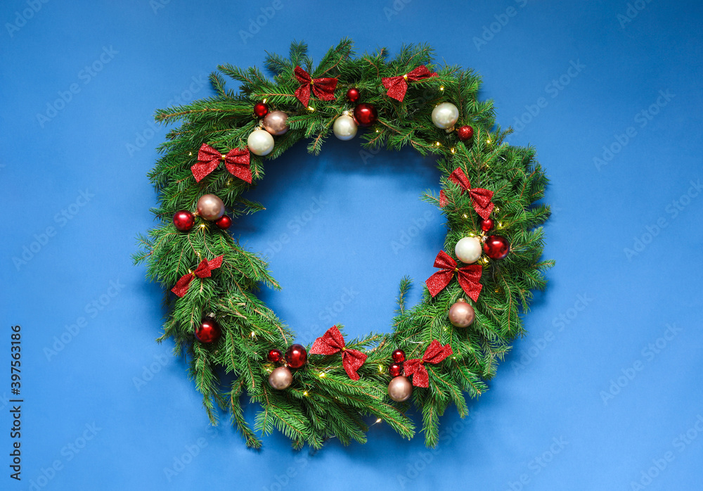 Beautiful Christmas wreath with festive decor on blue background, top view Beautiful Christmas wreath with festive decor on blue background, top view