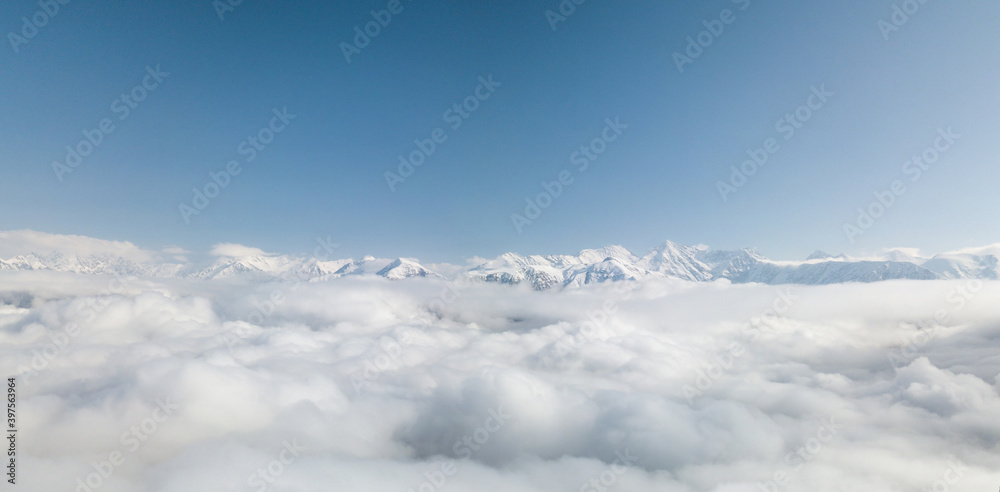 Aerial view from above of clouds. Rosa Khutor Ski Resort, mountains covered by snow in Krasnaya Polyana, Russia. Aerial view from above of clouds. Rosa Khutor Ski Resort, mountains covered by snow in Krasnaya Polyana, Russia.