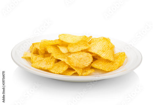 Plate of tasty ridged potato chips on white background