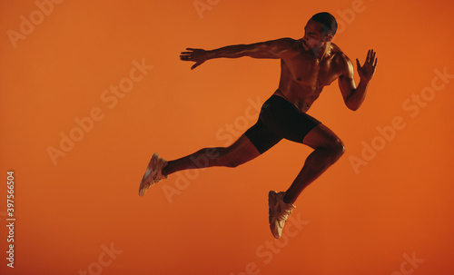 Bare chested male athlete running