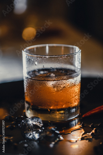 Refreshing alcoholic cocktail. Whiskey and coke. Ice in a glass, mixing ingredients.