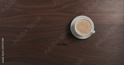 Top view hot chocolate in white cup on walnut wood table