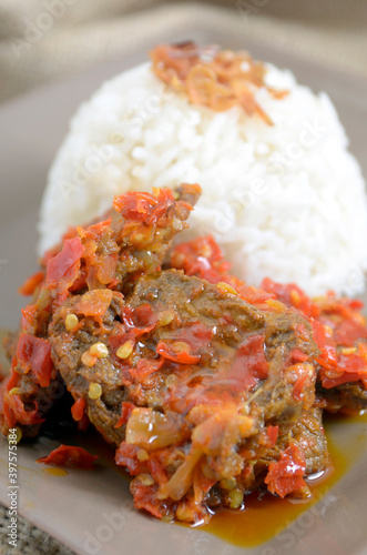 Dendeng Balado or Dendeng Batokok, and is a speciality from Padang, West Sumatra, Indonesia. Made from beef which is thinly cut then dried and fried before adding chillies and other ingredients photo