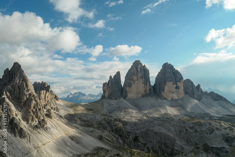 A panoramic capture of the famous Tre Cime di Lavaredo (Drei Zinnen) and surrounding mountains in Italian Dolomites. The mountains are surrounded by thick clouds. A lot of landslides. Serenity
