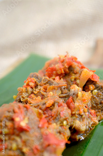 Dendeng Balado or Dendeng Batokok, and is a speciality from Padang, West Sumatra, Indonesia. Made from beef which is thinly cut then dried and fried before adding chillies and other ingredients photo