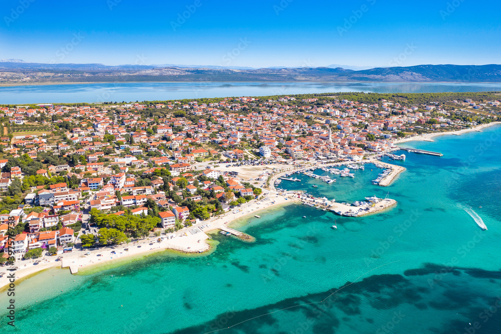 Town of Pakostane on Adriatic sea coast in Croatia and Vransko lake in background, aerial view