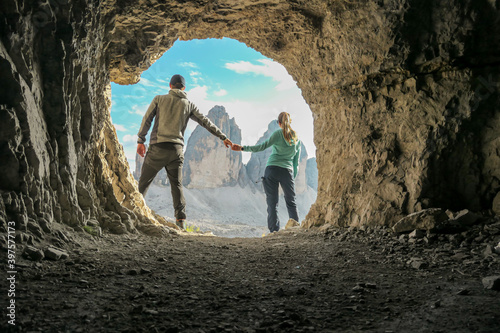 Foto A couple standing in front of a cave, with the view on the Tre Cime (Drei Zinnen) in Italian Dolomites