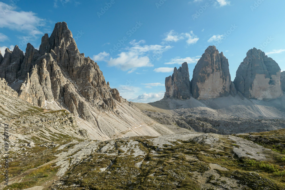 A panoramic capture of the famous Tre Cime di Lavaredo (Drei Zinnen) and surrounding mountains in Italian Dolomites. The mountains are surrounded by thick clouds. A lot of landslides. Serenity