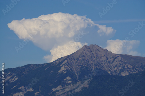 puffy white mushroom cloud over the mountains of the French Alps