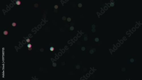 Colorful dust particles glimmering on black background. Beautiful easy to use as an overlay on your footage.