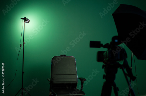 Green screen background and a black chair in a television Studio. photo