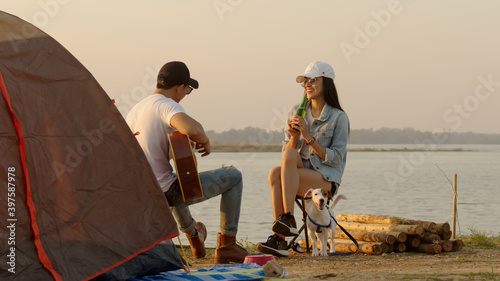 Couple at campsite after make tent playing guitar and sing together