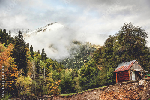 Little house on the cliff by the river in the Caucasus mountains