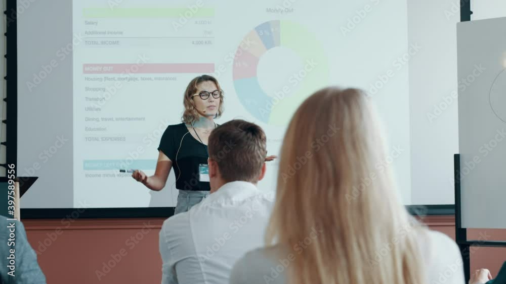 Businesswoman giving presentation at a conference with audience clapping. Female entrepreneur getting applause from attendees at a seminar.
