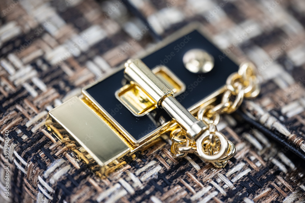 Close up of the lock of a ladies handbag. Fabric bag with gold clasp. Fashion concept Luxury fabric woman's handbag. Golden lock of a fashionable bag. detailed Top view Close up of the lock of a ladies handbag. Fabric bag with gold clasp. Fashion concept Luxury fabric woman's handbag. Golden lock of a fashionable bag. detailed Top view