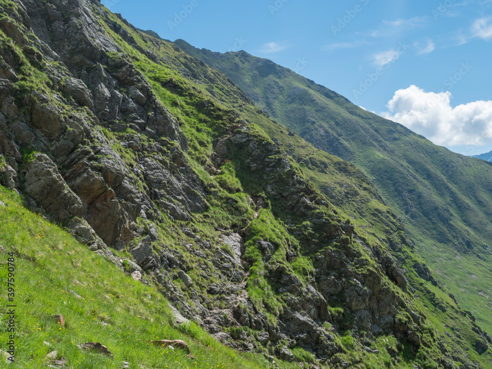 Steep grassy rock face with via ferrata, protected climbing route, marked path of Stubai hiking trail, Stubai Hohenweg, Tyrol Alps, Austria