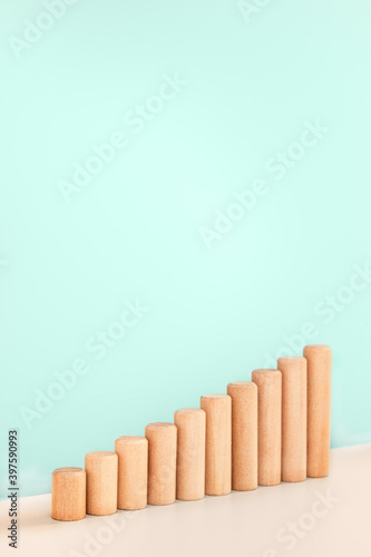 Growth bar chart  graph diagram made with wooden block on blue background and copy space. Business progress strategy  sales and marketing concept. Vertical orientation