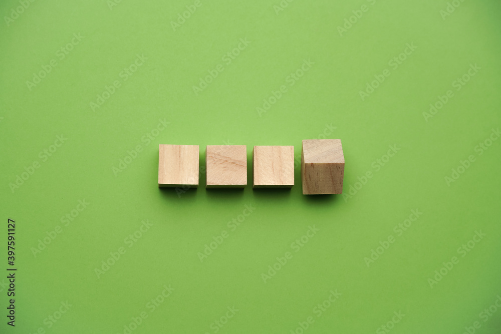 A wooden cube on green backgroud, business, finance and education concept A wooden cube on green backgroud, business, finance and education concept