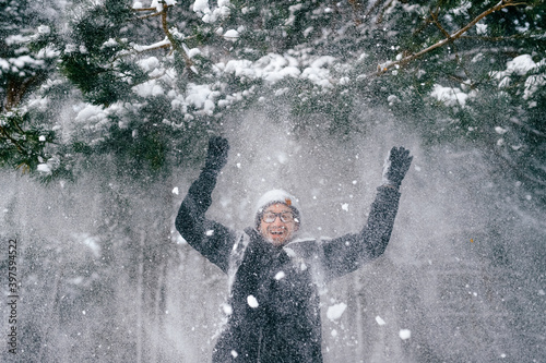 Happy smiling man under tha falling snow