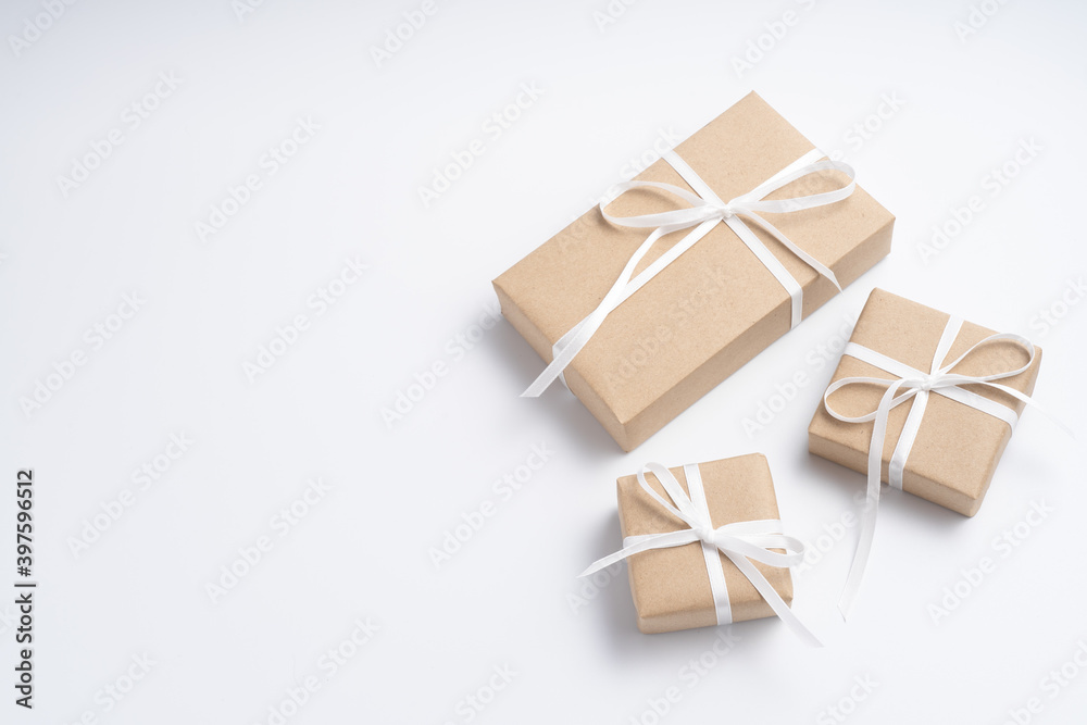 Brown gift box tied with white ribbon on clear background