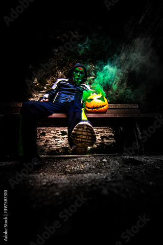 Purge mask, halloween with pumpkin. LED mask, creepy scary man. Corona, Funny, October, outside. Urban scene © Jan