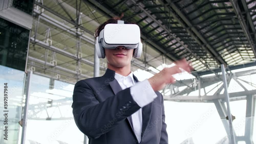Slow motion of mature asian man employee wearing vr glasses moving arms gesturing enjoying cool device in office. Modern technology and fun concept.. Slow motion of mature asian man employee wearing vr glasses moving arms gesturing enjoying cool device in office. Modern technology and fun concept..