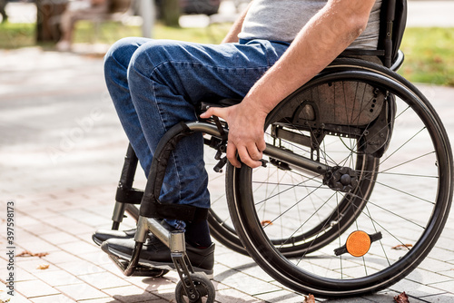 Handicapped man in wheelchair walk at the park alley