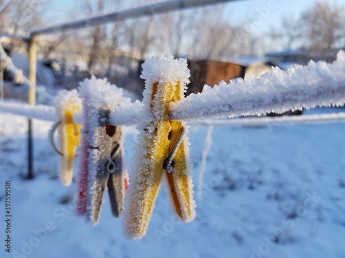 Frozen clothespins hang from a rope