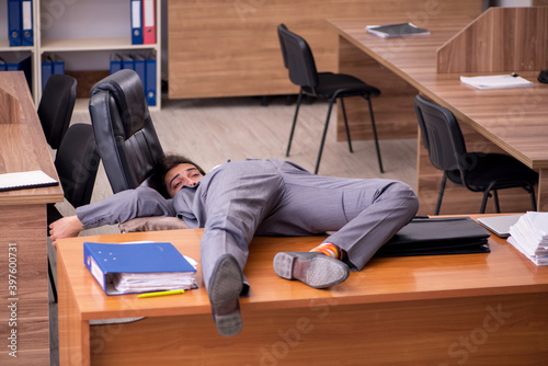 Young male employee sleeping at workplace © Elnur