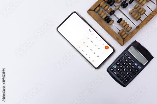 Technological progress concept. Calculation, counting technologies development. Old wooden abacuses, calculator and smartphone with calculator on white background. Top view. Blank space