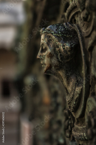 Sculpture de femme de profil sur une grille © Nathan
