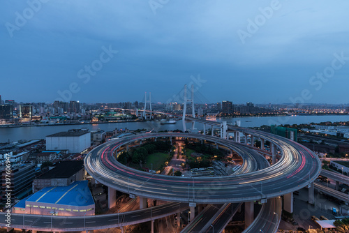Fototapeta Naklejka Na Ścianę i Meble -  Aerial view of Nanpu Bridge at dusk, landscape of the modern Shanghai city skyline. Beautiful night view of the busy bridge across Huangpu River